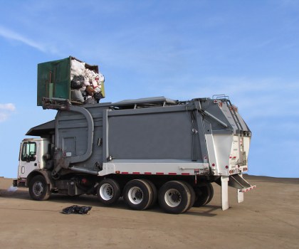 Company representative reviewing a complaints form near a skip
