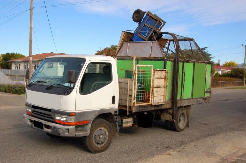 Low-carbon vans lined up for skip collections in an urban neighbourhood